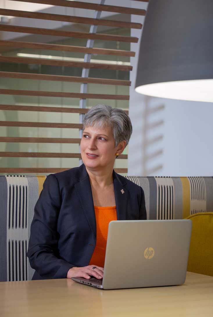 environmental pr headshot of Jane Englebright at a desk with her laptop