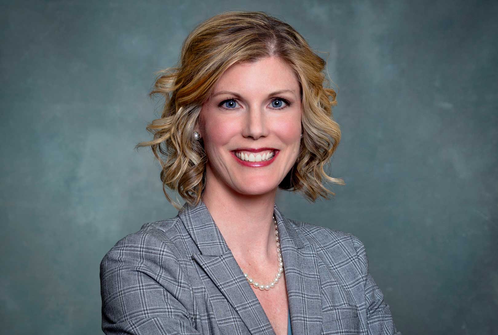 corporate headshot on gray background of attorney Joy Longnecker