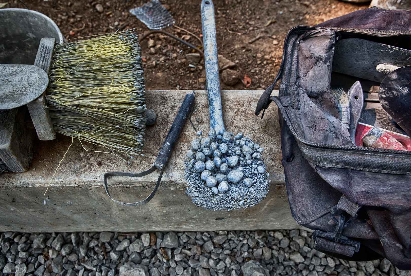 round concrete brush on ledge with other tools