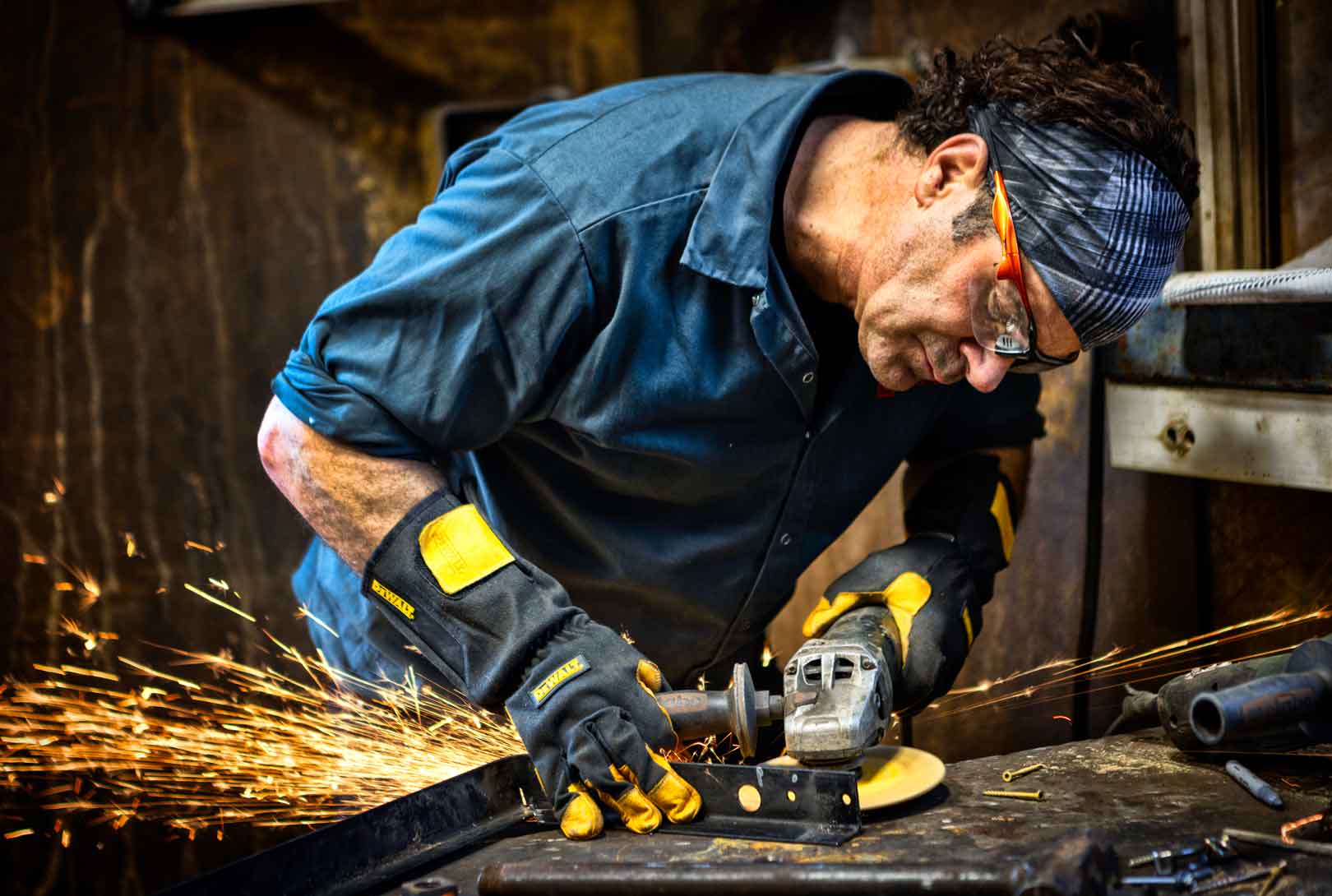 sculptor Valentine Adams cutting metal in his studio