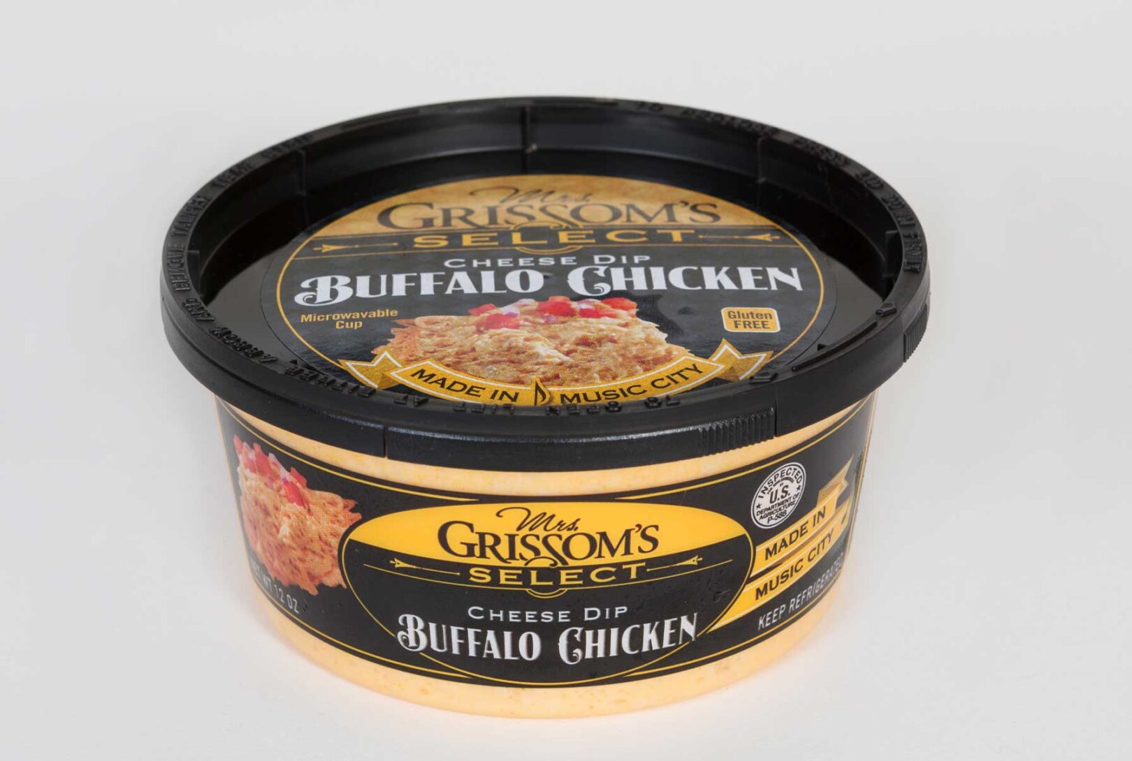 A tub of Mrs. Grissom buffalo chicken cheese dip on a white background.