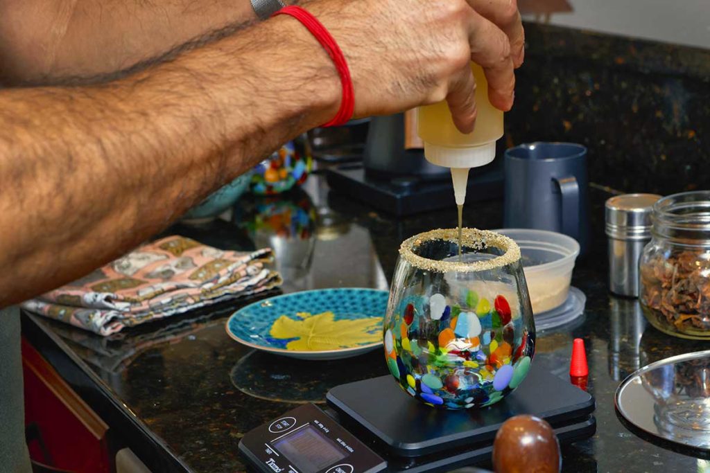 adding ginger spice syrup into a glass
