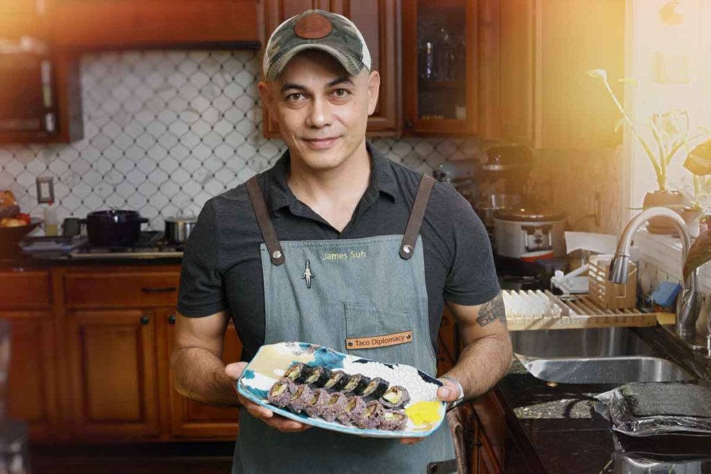 James Suh with plate of seaweed rolls