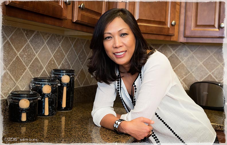 A portrait of Loan Hillsten in her kitchen as she shares her story as a 1975 Vietnamese Refugee coming to America for blog series Fabulous Women Over 40