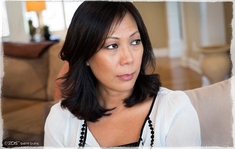 A portrait of Loan Hillsten on her couch sharing her story as a 12 year old Vietnamese Refugee in 1975 for the photo blog series Fabulous Women Over 40