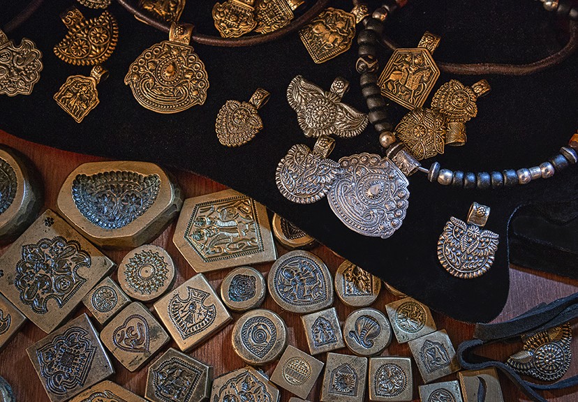 Metal clay pendants and the metal dye cut molds used to make them on a table top