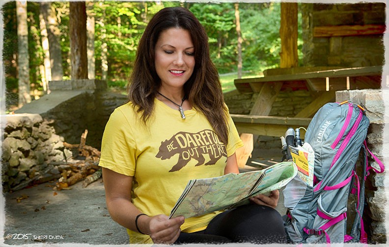 Fabulous Women over 40, Payge McMahon, adventure athlete, motivational speaker, journalist, and yoga instructor at Percy Warner Park in yellow looking at a map