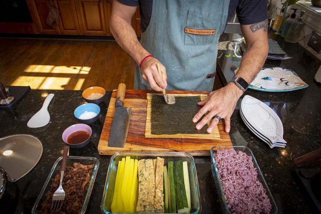 adding sesame oil to a sheet of seaweed