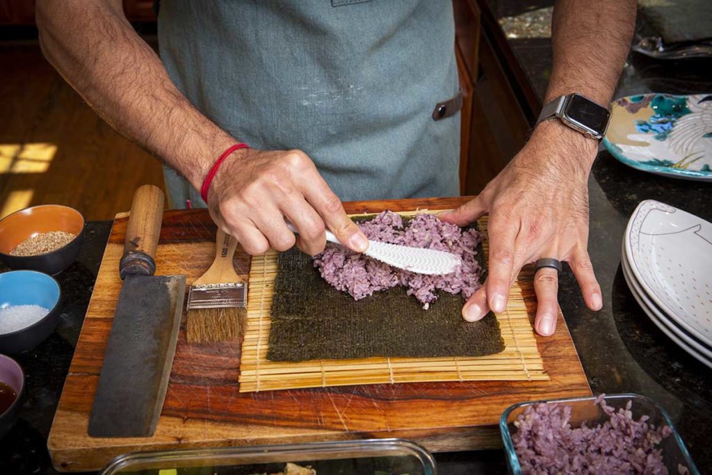 spreading sticky rice to seaweed roll