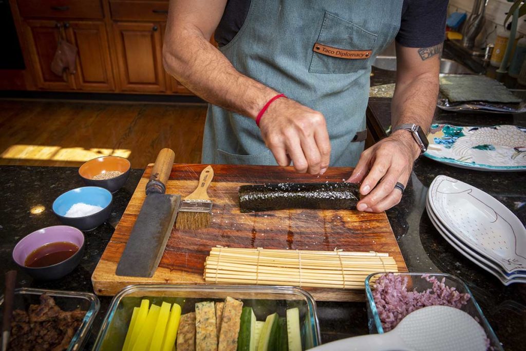 Sprinkling sea salt on seaweed rolls