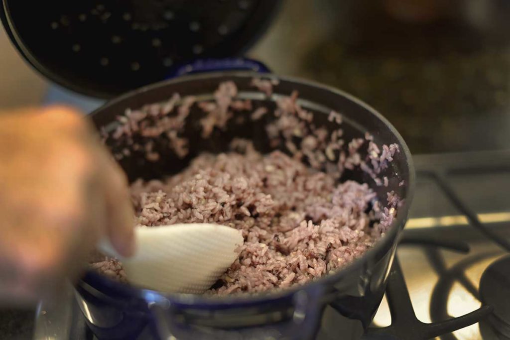 stirring a pot of sticky rice for seaweed rolls